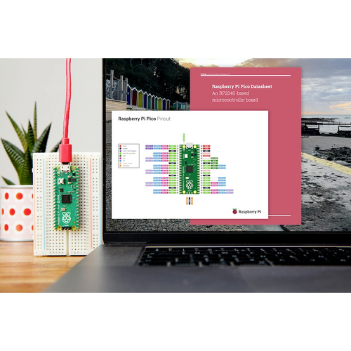Laptop mit geöffneter Raspberry Pi Pico Pinout-Diagramm-Webseite auf dem Bildschirm. Daneben auf einer Platine montierter Raspberry Pi Pico.